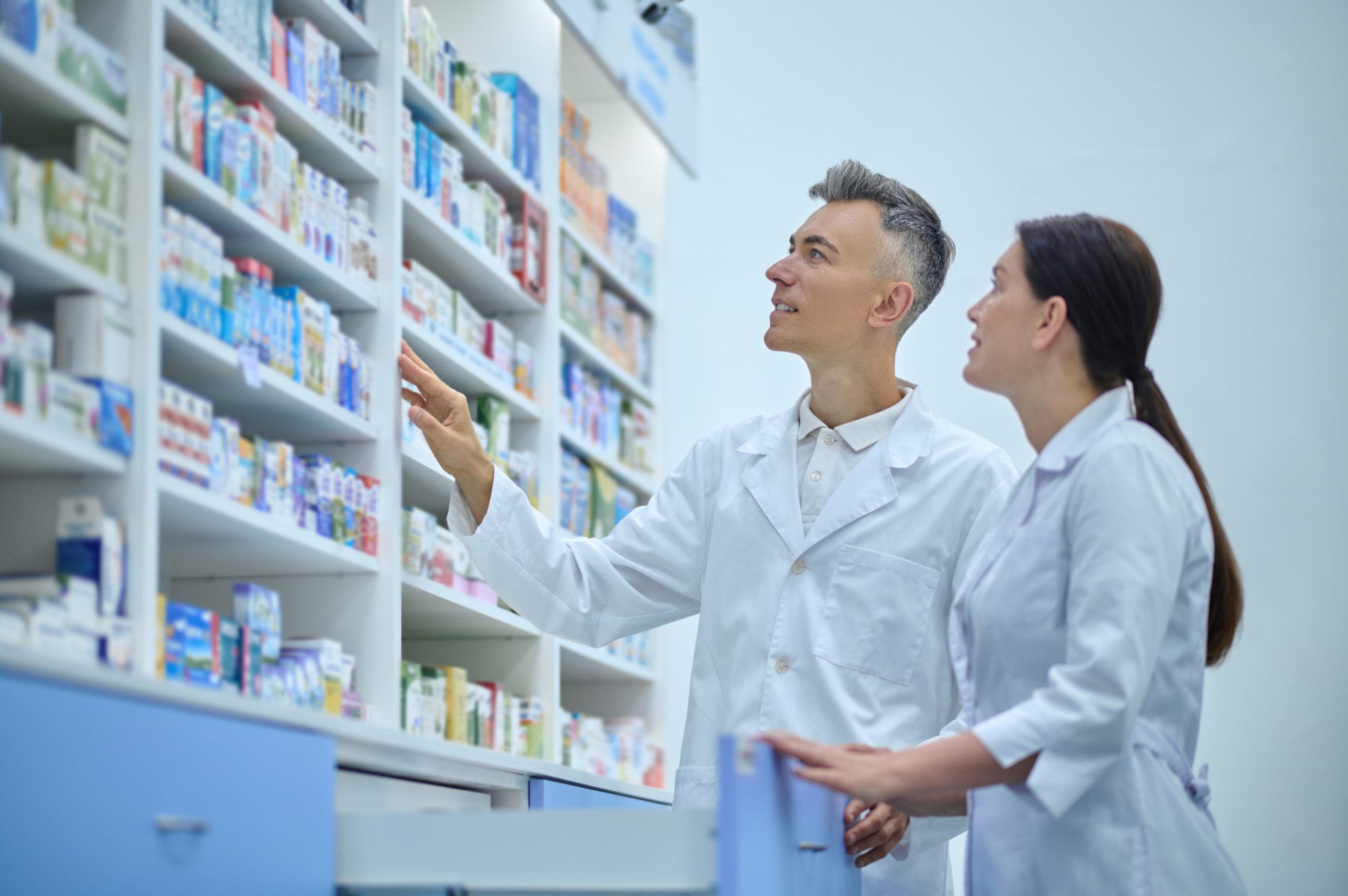 Two druggists in lab coats in the process of inventory in a drugstore
